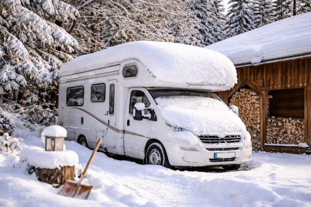 Wohnmobil im Winter auf privatem Stellplatz mit Schnee bedeckt – Symbolbild für Ruheversicherung bei Saisonkennzeichen oder Fahrzeugabmeldung